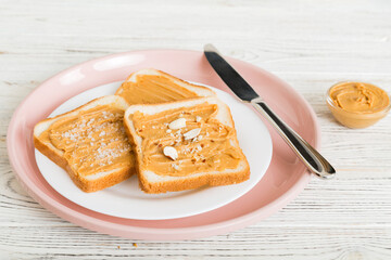 Peanut butter sandwiches or toasts on light table background.Breakfast. Vegetarian food. American cuisine top view vith copy space