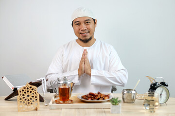Muslim Man Gesture Welcoming and Greeting For Ramadan with Iftar Food and Ramadan Decoration On The Table 