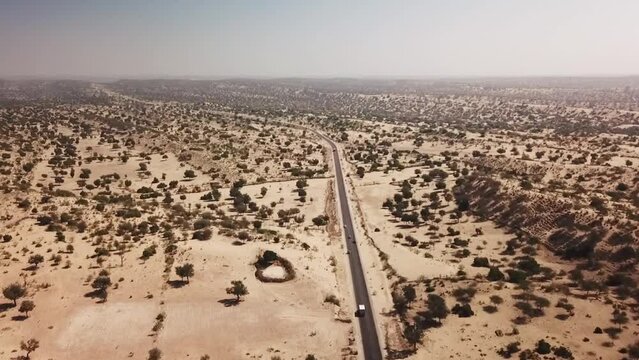 Aerial view of road with cars running trough it in Thar desert, Sindh, Pakistan.