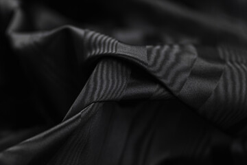 Close-up of texture of black taffeta (silk) fabric with black stripes pattern. Background, texture...