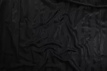 Fotobehang Texture of black taffeta (silk) fabric with black stripes pattern, top view. Background, texture of draped dressy fabric with shining black stripes pattern. © Владимир Трубачёв