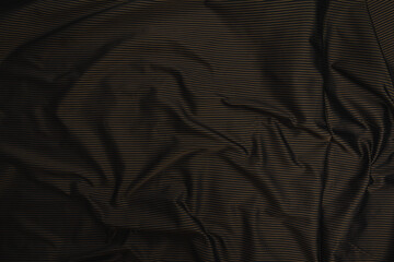 Ttexture of black lana wool fabric with pattern of thin stripes of gold color, top view....