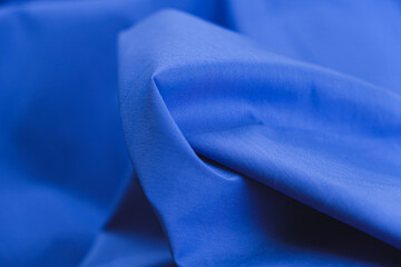 Close-up of texture of cotton fabric in blue color. Background, texture of draped fabric without...