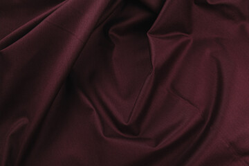 Texture of cotton fabric in wine red color, top view. Background, texture of draped fabric without...