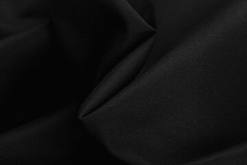 Close-up of texture of cotton fabric of black color. Background, texture of draped fabric without...