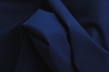 Close-up of texture of cotton fabric in dark blue color. Background, texture of draped fabric...
