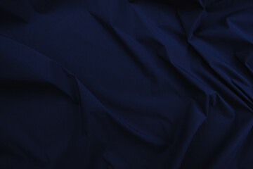 Texture of cotton fabric in dark blue color, top view. Background, texture of draped fabric without...