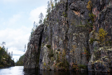 A large cliff next to canyon lake called Julma Ölkky on an autumn day in Hossa National Park, Northern Finland	