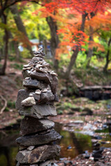The tower of stacked stones in the autumn stream