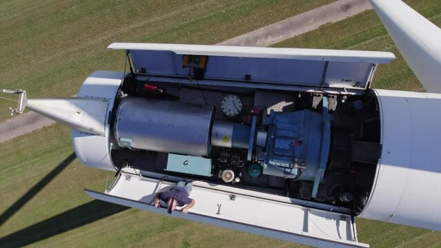 Friesland, Netherlands - 22 May 2023: Aerial view of engineer performing repairing and maintenance works on top of wind turbine,Friesland, Netherlands.