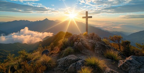 Silhouettes of crucifix symbol on top mountain with bright sunlight on the colorful sky background.