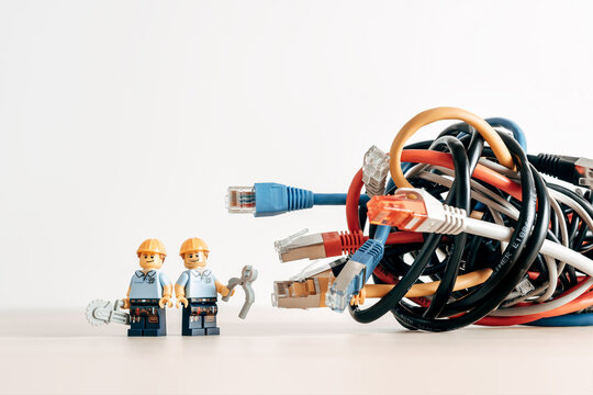Technicians and a tangled bunch of network cables. Illustrative editorial. Illustrative editorial