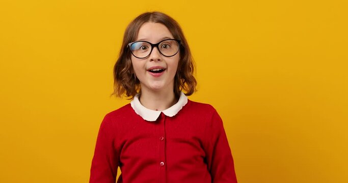 Teenage Schoolgirl Trying On Glasses to Improve Vision Against Yellow Background