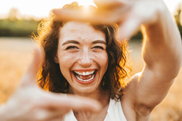 Close up of smiling woman making frame gesture with hands - 758768316