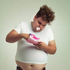 Food, hunger and marshmallow with plus size man in studio on gray background for unhealthy eating....