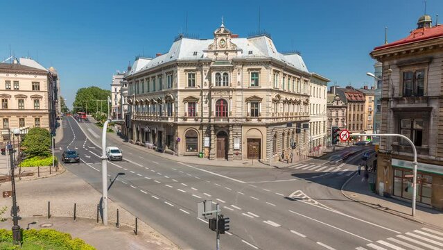 Busy traffic on intersection near Chrobry Square in Bielsko-Biala timelapse, Poland. Historic buildings aerial view from Sulkowski Castle. People crossing the road. Sunny day with a blue sky