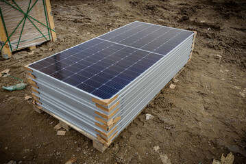 Solar modules at the construction site of a photovoltaic park. Stacked solar panels used for...
