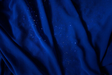 Blue fabric. Blue background. Fabric texture. Sparkles. Luxurious textiles. Waves