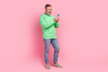 Full body photo of nice retired male hold telephone ecommerce wear trendy green outfit isolated on pink color background