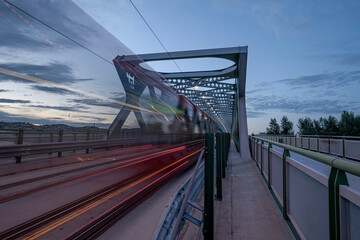 A long exposure of the traffic with blurred tram on the old bridge over the Danube river in the...