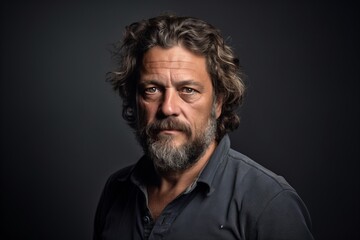 Handsome middle aged man with long grey hair and beard in a studio portrait