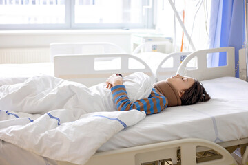 Preteen child, boy, lying in hospital with fractured thoracic spine, vertebralis