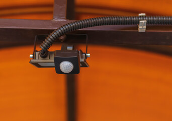 A searchlight with a motion sensor on a metal roof for lighting the backyard and the surrounding area