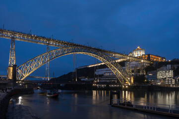 Night view of Porto with Dom Luis I Bridge, Duoro river and Mosteiro da Serra do Pilar with reflection in water