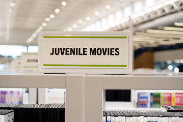 Row of diverse DVD, Blu-ray, CD, multimedia, digital content in Juvenile collection display at large public library in Frisco, Texas, digital content for teenager interactive learning education