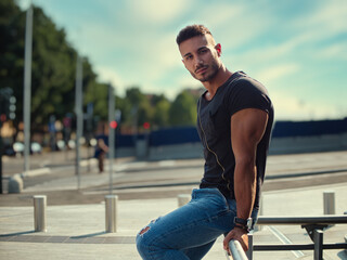 Obraz premium A man is seated on the metal bench, looking out into the distance. He appears relaxed and thoughtful as he takes in the surroundings.