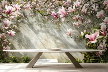 Fototapeten A sleek bench awaits in a tranquil garden, surrounded by the soft pink of magnolia blooms © nnattalli