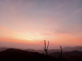 Obraz premium The sky has purple-orange tones in the early morning as the sun rises over the mountains