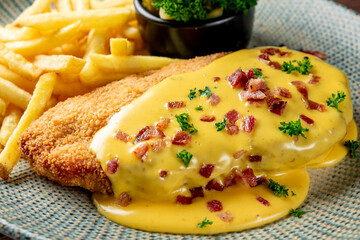 Fried Wiener chicken schnitzel with French fries and cheese sauce