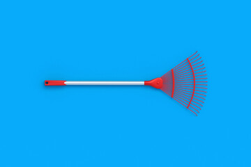 Leaf rake for leaves on blue background. Gardening equipment. Yard and lawn cleaning during fall season. Agriculture tool. Top view. 3d render