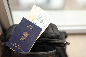 Blue Indian passport with airline tickets on touristic backpack close up. Tourism and travel concept