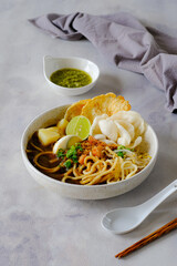 emie, Indonesian noodle with shrimp broth, dry shrimp, , fried onion,onion leaves, bolied potatoes, egg and crackers