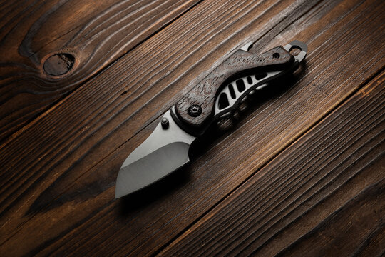 Tactical knife on a wooden background