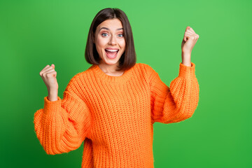 Portrait of pretty overjoyed lady raise fists triumph accomplishment empty space isolated on green...