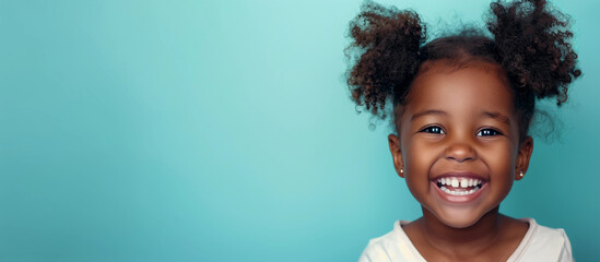 One smiling laughing youth 5 yr old girl African American pigtail curls hair portrait isolated blue empty indoor background child dental oral teeth childcare education wellness kid concept copyspace