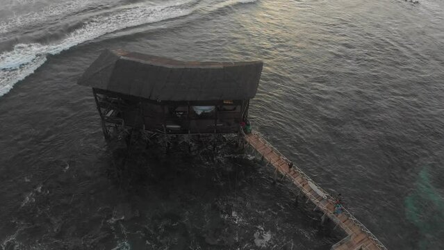 Aerial view of surfer walks on wooden walkway to cross the reef, Cloud9, Siargao, Philippines