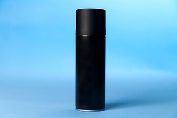 Black spray can on blue background. Can concept. Product concept.