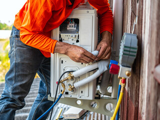 Air conditioning technicians install new compressor air in homes, Repairman fix air conditioning systems, Male technician service for repair and maintenance of air conditioners