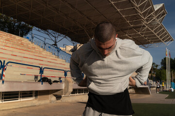 Athlete arriving at the track taking off his sweatshirt to start training. Concept of sport and...
