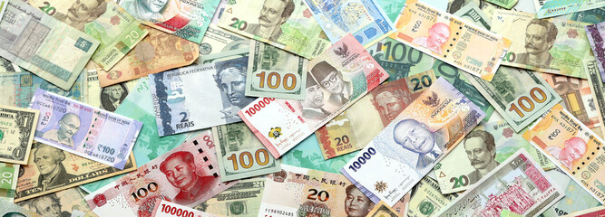 Many banknotes of different currency. Background of big amount of random money bills close up