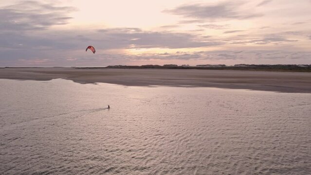 Aerial view of person kitesurfing at waddensea during sunset, Terschelling, Netherlands