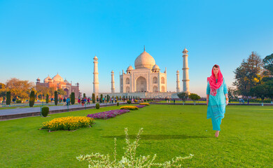 Young woman in traditional indian clothes in front of Taj Mahal in Agra