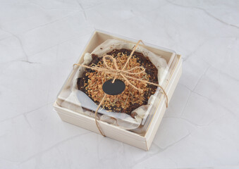 premium freshly baked dark cocoa chocolate brownie gold flower and earl grey peanut round birthday cake with walnut in wood bento box on white marble halal food sweet dessert menu for pastry cafe shop