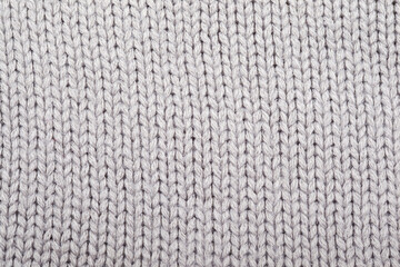The texture of a knitted woolen fabric gray. Background