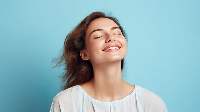 Portrait of a calm happy smiling free woman with closed eyes enjoying a beautiful moment life. isolated on pastel blue background