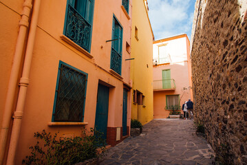 Rue de Collioure. Touristes à Collioure. Façades colorées dans un village de Provence. Village méditerranéen. Retraités au soleil. Personnes âgées dans un village du sud. Rue de Collioure